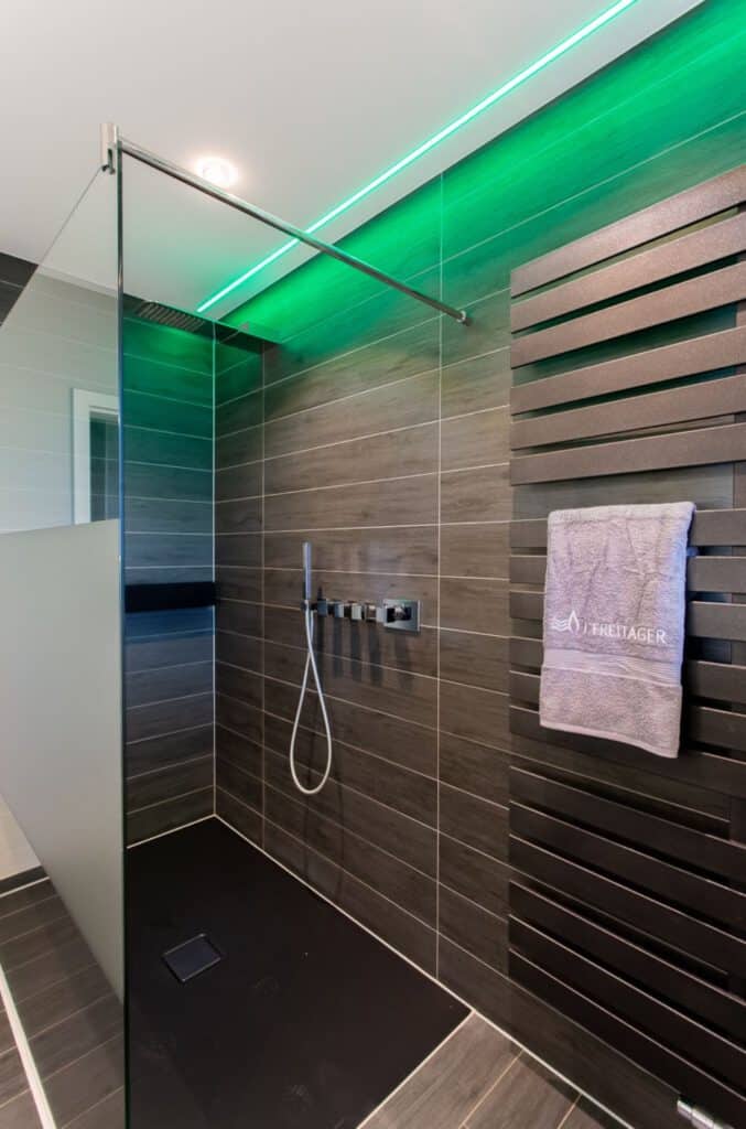 Blick in barrierefreie Dusche mit grüner Deckenrand-Beleuchtung