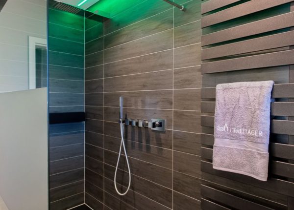 Blick in barrierefreie Dusche mit grüner Deckenrand-Beleuchtung